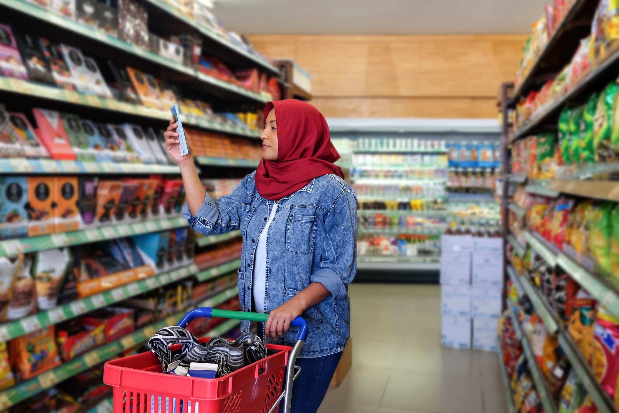Southeast Asian muslim woman reading food label of a chocolate bar
