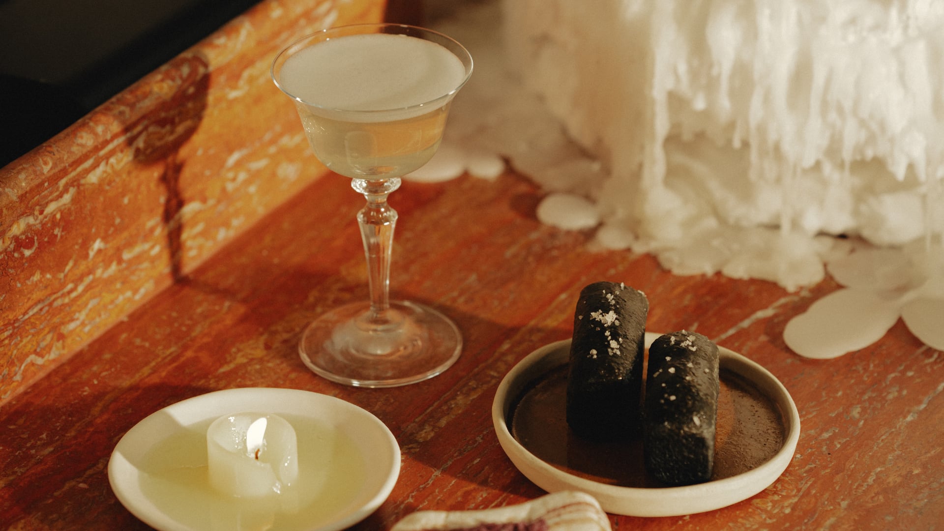Tallow candle with charcoal sourdough, served alongside a quail tallow-infused cocktail.