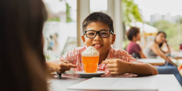 Child holding drink with cream on top