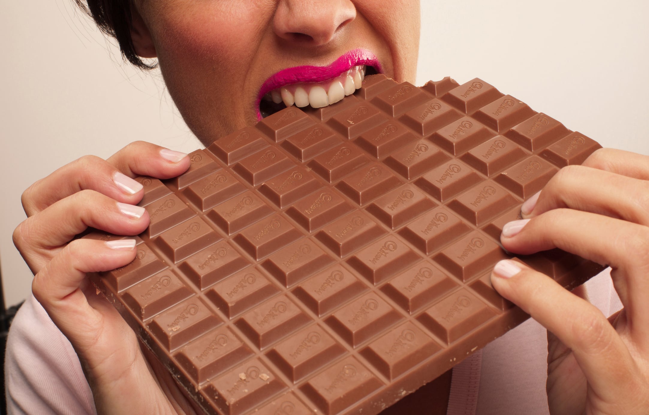 Woman eating a giant bar of Cadbury's chocolate