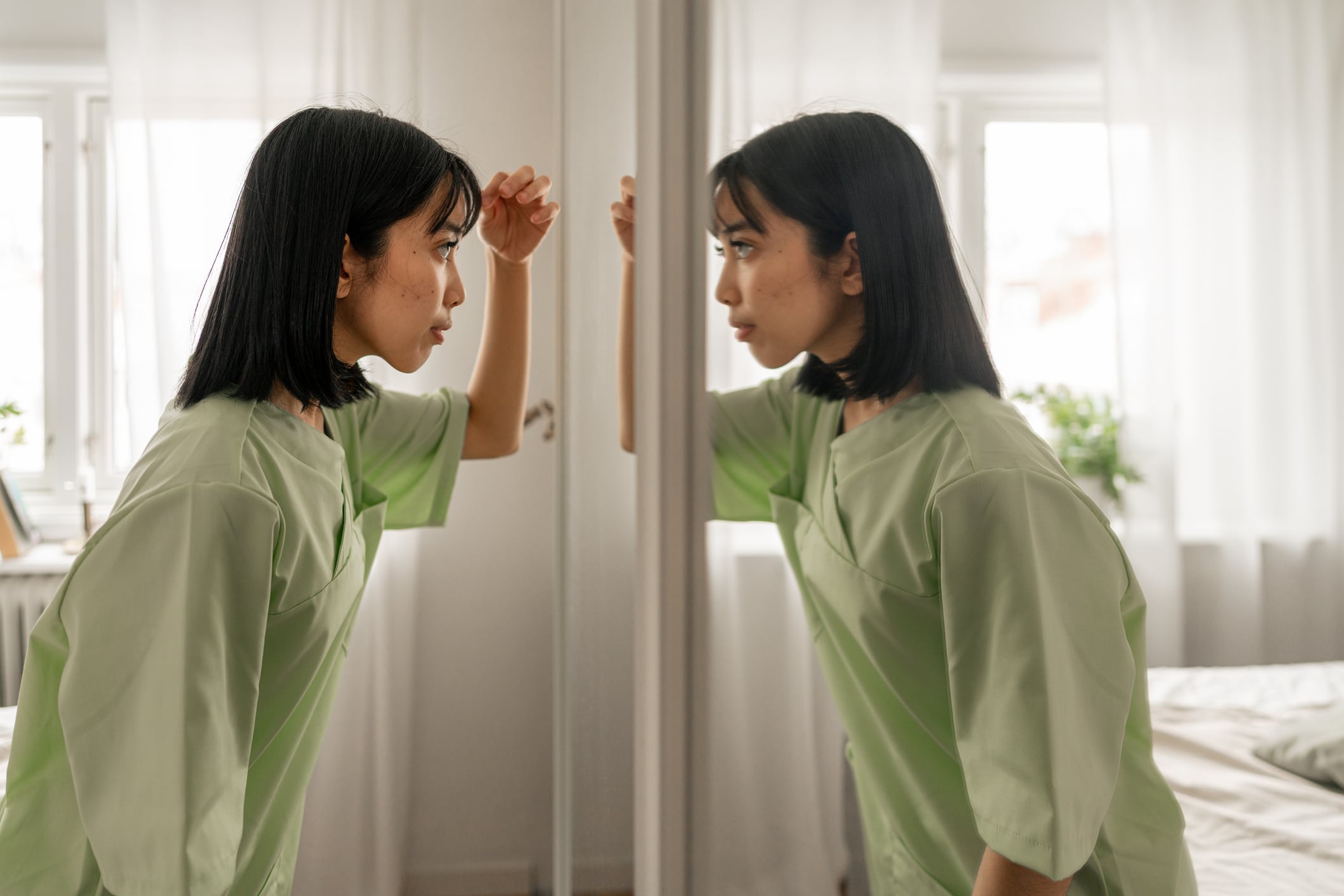 Woman checking her appearance in front of the mirror in the morning.