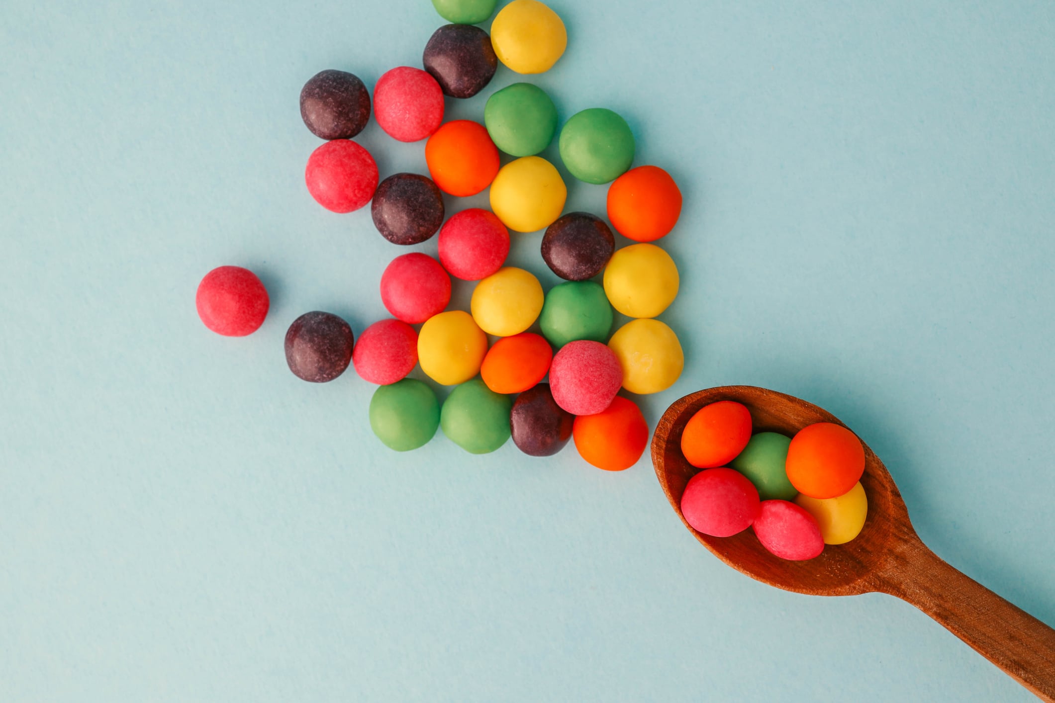 Chocolate round candies scattered on a soft blue background.