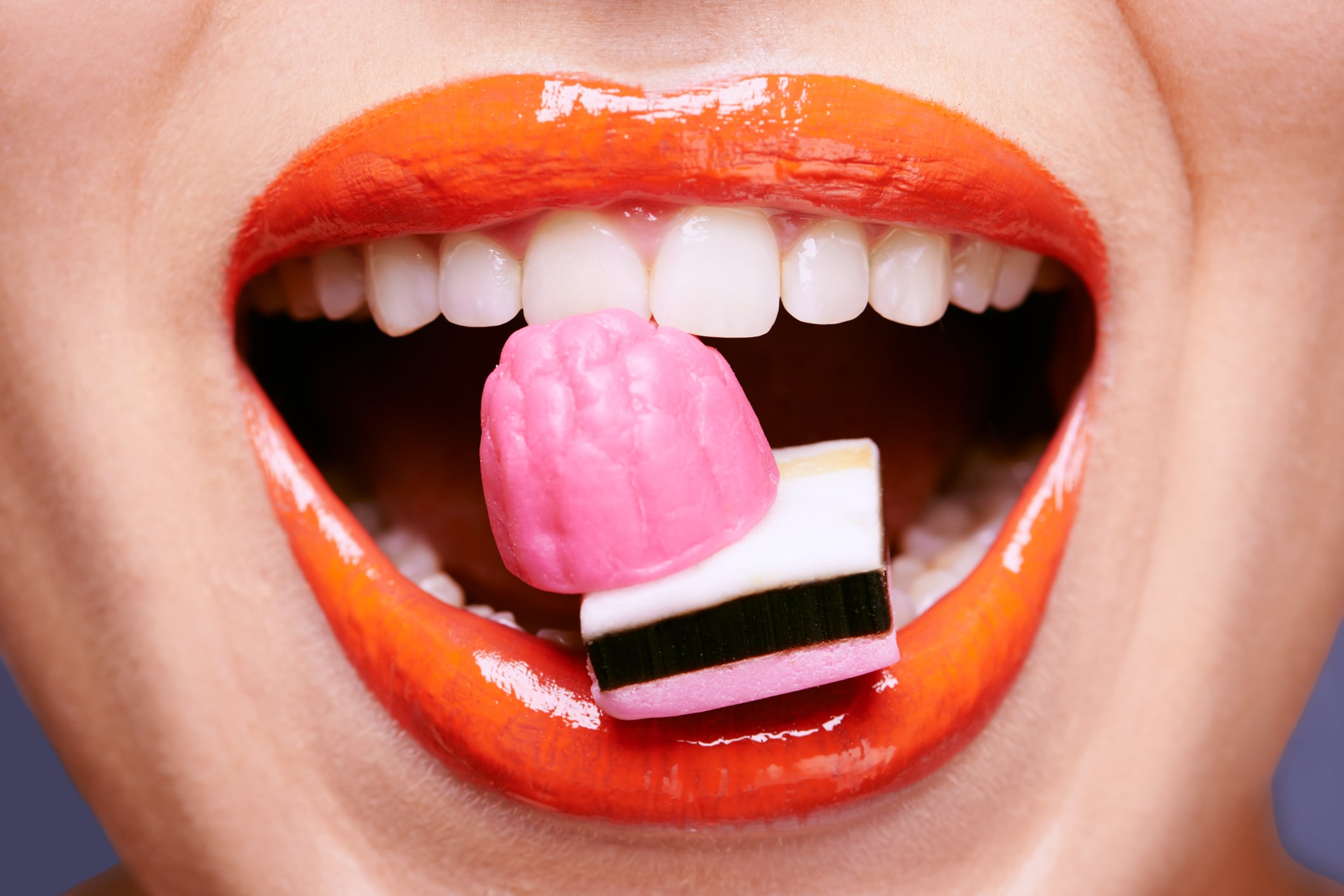 Cropped shot of a beautiful young woman eating liquorice