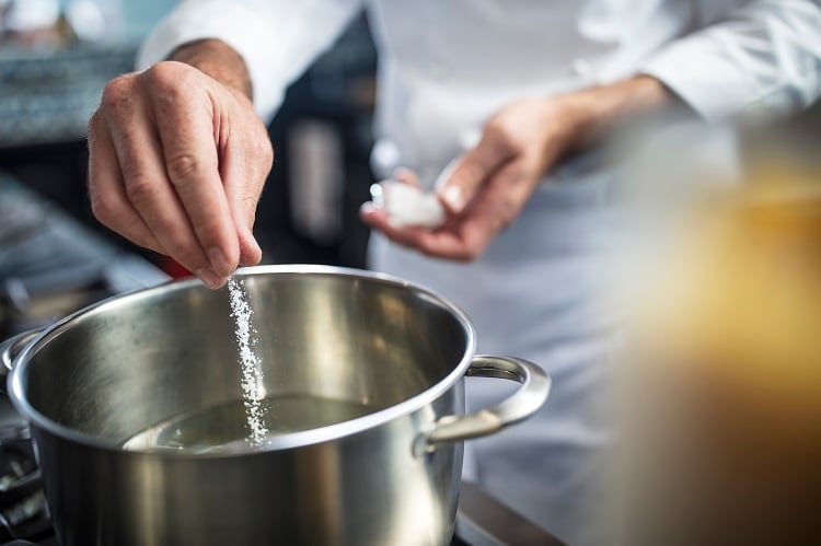 Man putting salt in pan