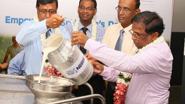 Nagalingam Vethanayahan, Government Agent of Jaffna, and Nestlé officials pouring milk from the first milk can. Pic: ©Nestlé