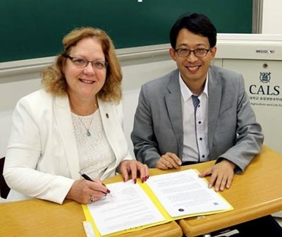 Picture: Washington State University. Rasco, left, and Kang sign MOU